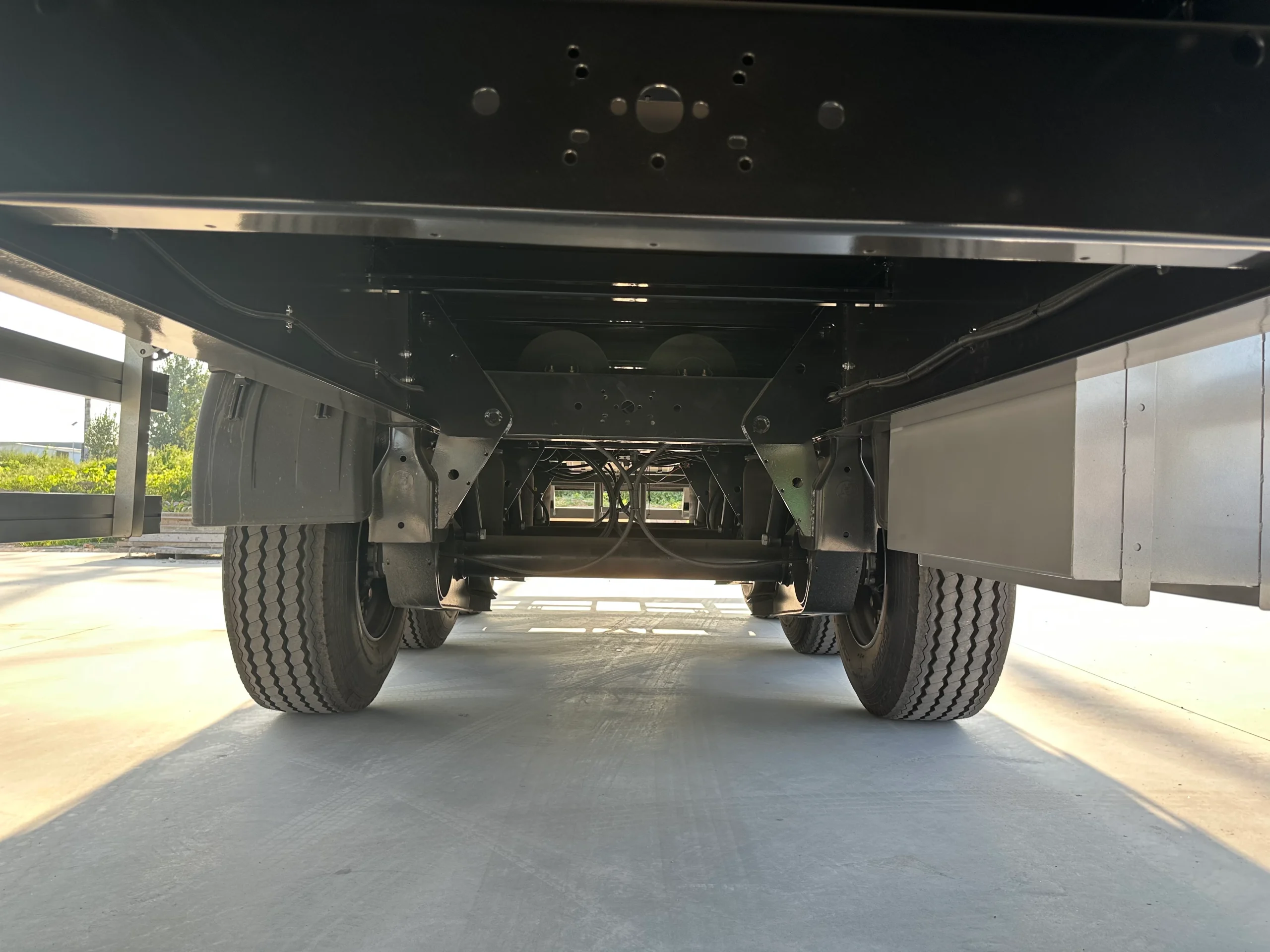 Chassis beams and crossmembers beneath the curtain side trailer cargo floor